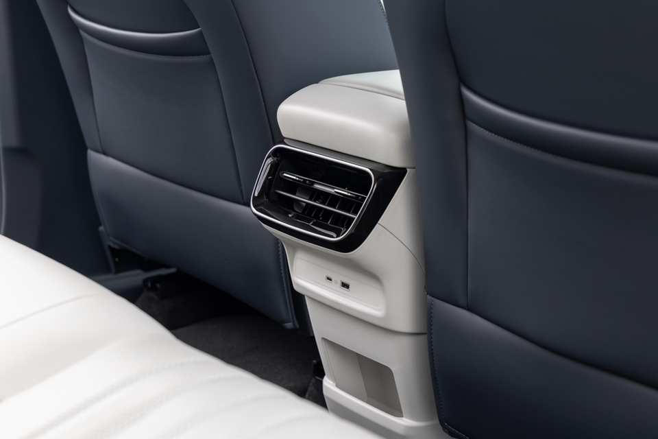 Rear air vents and USB charging ports on the back of the centre console in the 2027 Geely Starray EM-i Inspire, between navy leather front seats