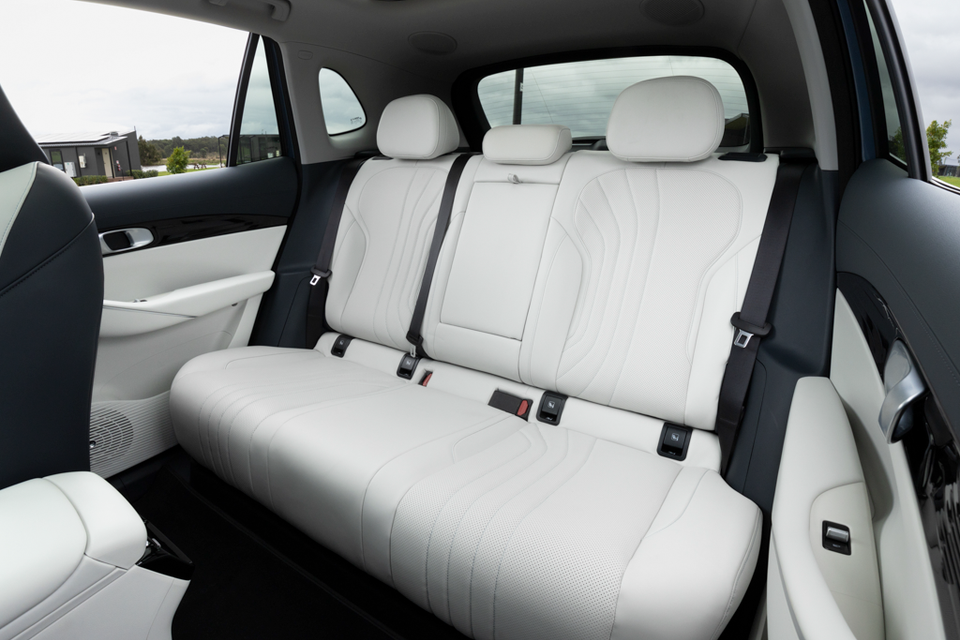 Rear bench seat of the 2027 Geely Starray EM-i Inspire trimmed in white quilted leather with black seatbelts and a centre headrest