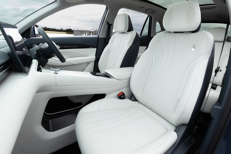 White leather front seats and centre console inside the 2027 Geely Starray EM-i Inspire, viewed through the open passenger door