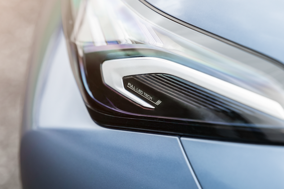 Close-up of the LED headlight on a grey 2027 Geely Starray EM-i Inspire, showing "Full LED Tech" lettering inside the lens.