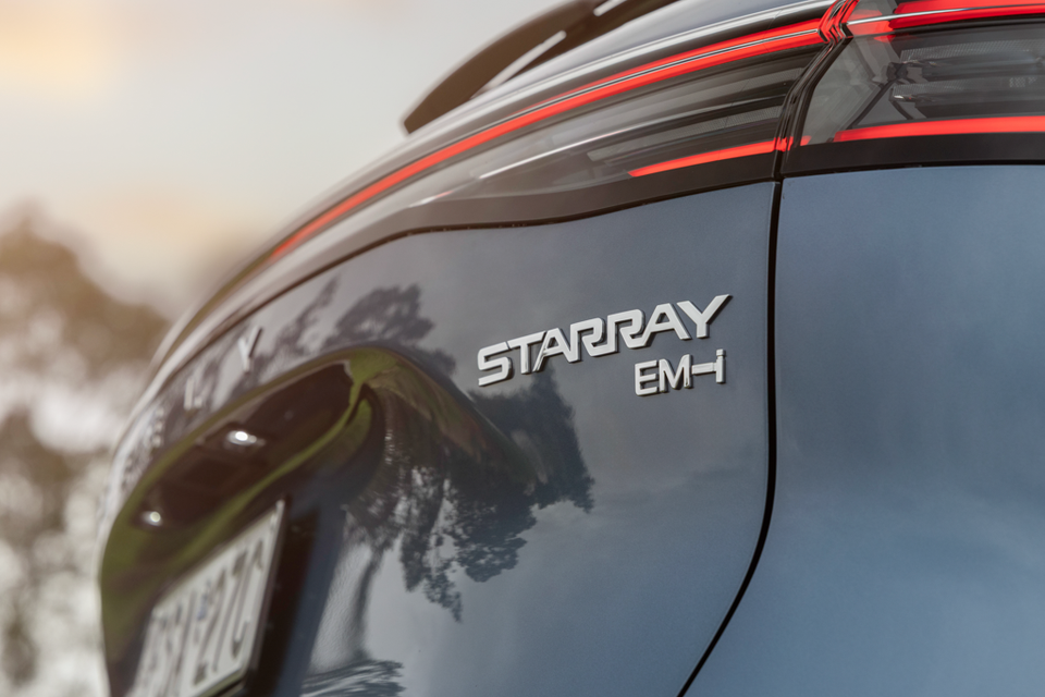 Close-up of the Starray EM-i badge on the tailgate of a dark grey 2027 Geely Starray EM-i SUV, beside its red LED tail-light