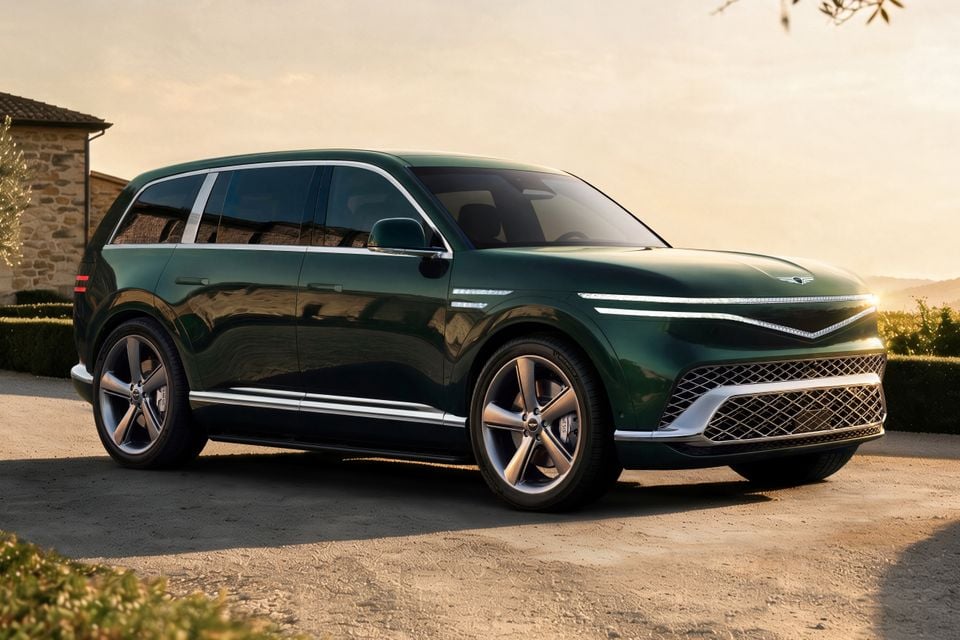 A dark green Genesis GV90 large SUV seen from the front-side angle, parked on a gravel driveway at sunset
