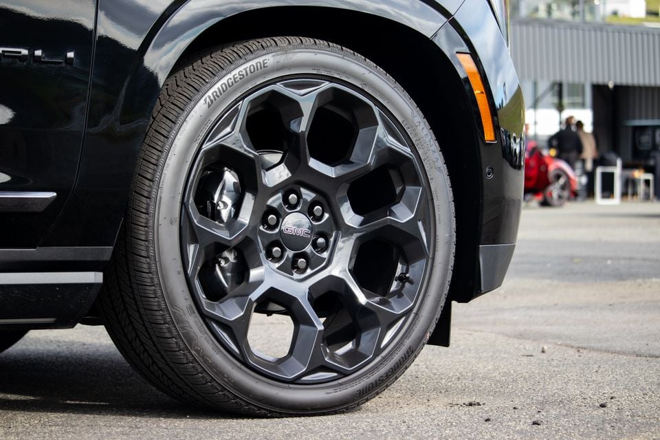 Close-up of a GMC Yukon's dark multi-spoke alloy wheel fitted with a Bridgestone tyre, on a black SUV