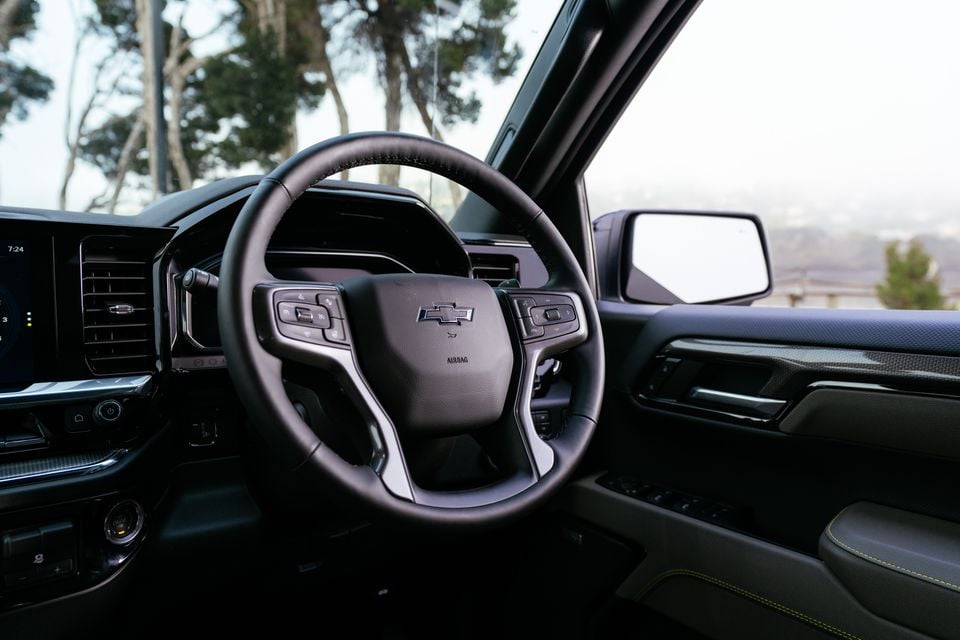 Interior view of a Chevrolet Silverado ZR2 showing the black leather steering wheel with Bowtie badge and the dashboard beyond