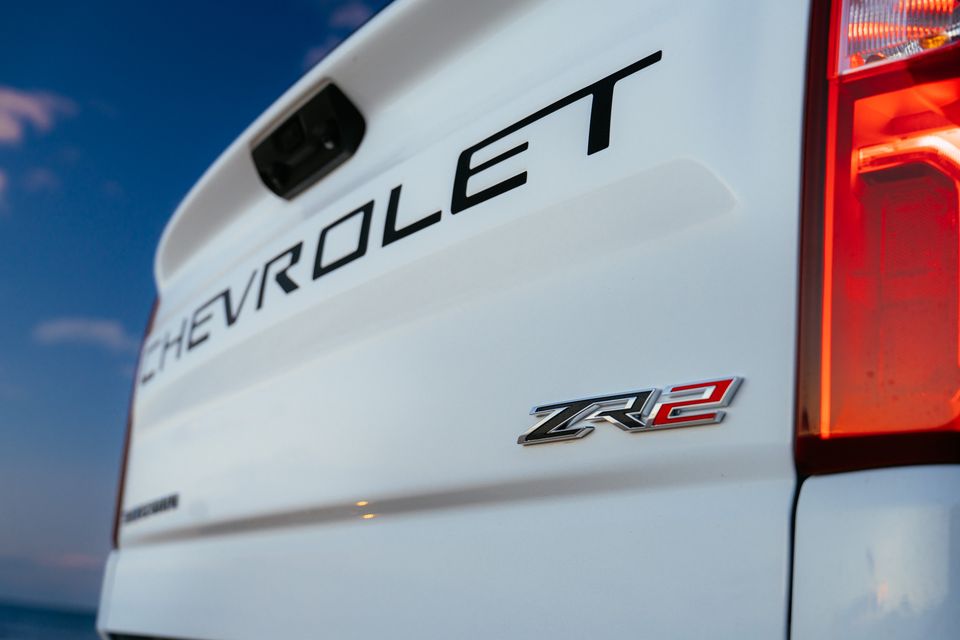 Close-up of the tailgate on a white Chevrolet Silverado ZR2, showing the Chevrolet lettering, ZR2 badge, and tail light.