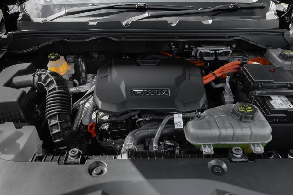 GWM engine bay showing the hybrid powertrain with orange high-voltage cables and GWM-branded engine cover