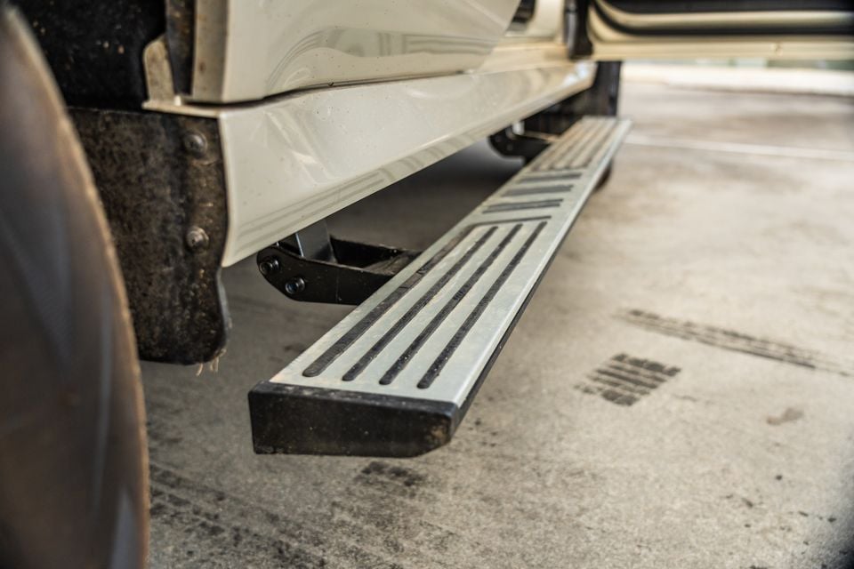 Close-up of the side running board on a white GWM Tank 500 Ultra PHEV, viewed from low angle in a car park