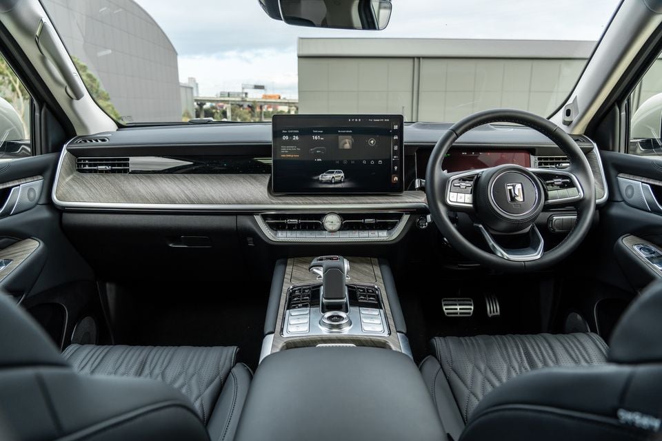 Interior of the 2027 GWM Tank 500 Ultra PHEV showing the dashboard, central touchscreen infotainment display, wood-trimmed centre console, and right-hand-drive steering wheel