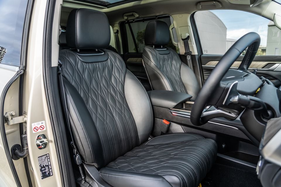 Black quilted leather front seats inside a GWM Tank 500 Ultra PHEV, viewed from the open driver's door with the steering wheel visible