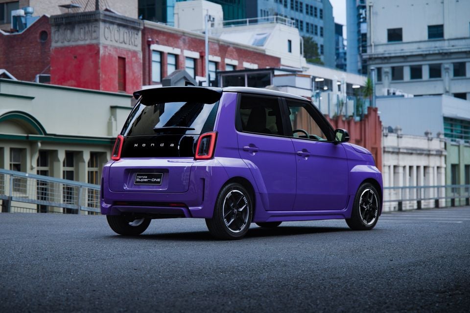 A purple 2027 Honda Super-ONE small hatchback parked on a city street, seen from the rear quarter