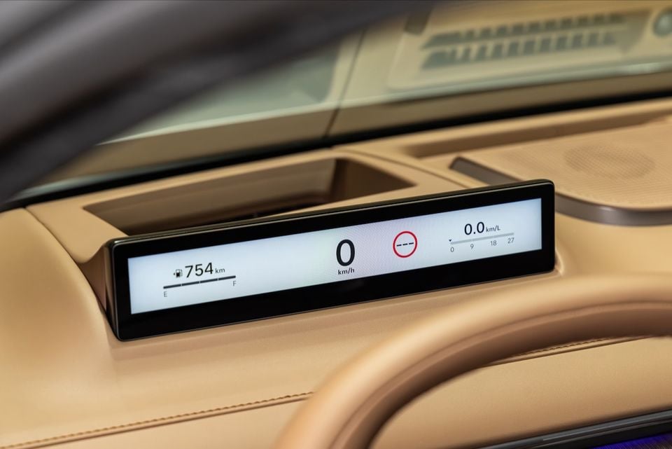A wide rectangular digital instrument cluster display on the dashboard of a 2027 Hyundai Grandeur, showing speed, fuel range, and fuel economy readings on a tan leather interior