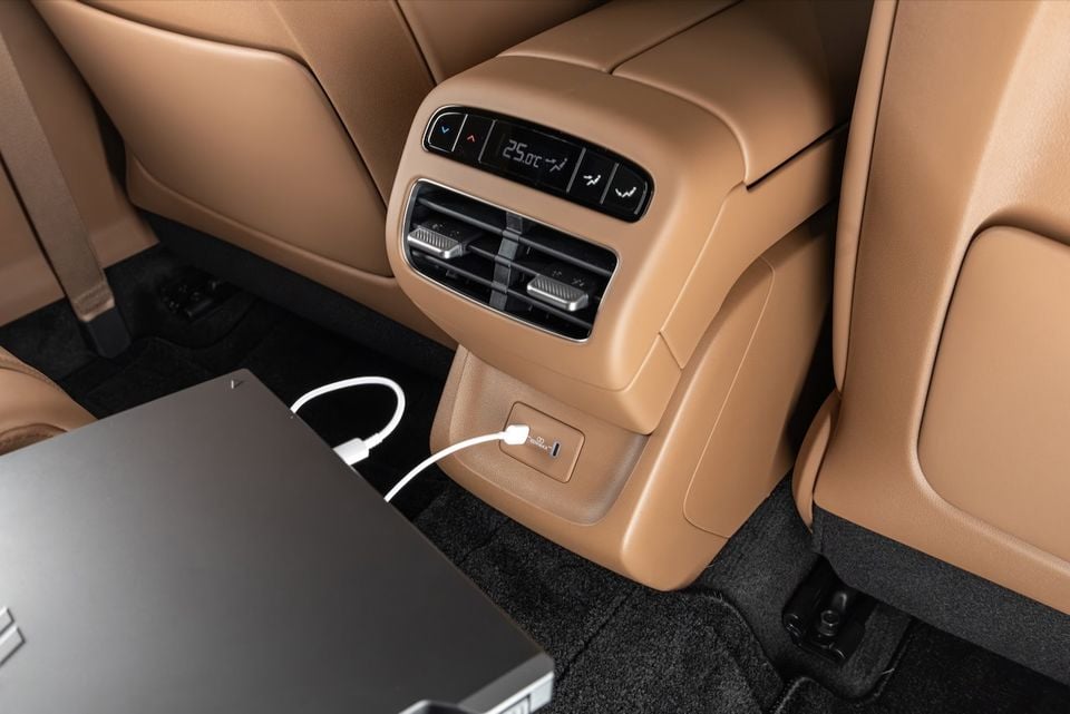 Rear interior of a 2027 Hyundai Grandeur showing the rear climate control panel with a 25°C display, air vents, and a USB charging port with a laptop plugged in, all finished in tan leather