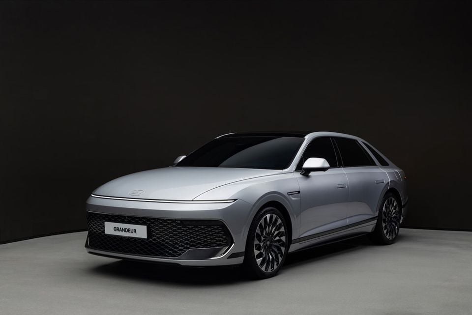 A silver Hyundai Grandeur large sedan photographed from the front-side angle in a studio setting