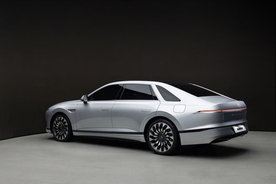 A silver Hyundai Grandeur sedan seen from the rear three-quarter angle in a studio setting