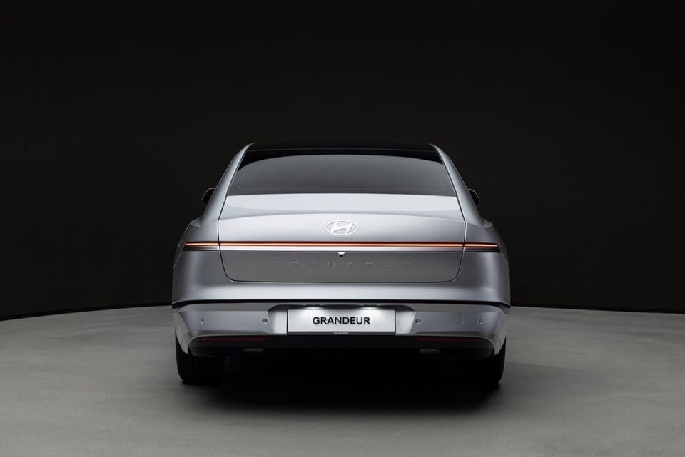 Rear view of a silver Hyundai Grandeur sedan photographed against a dark studio background