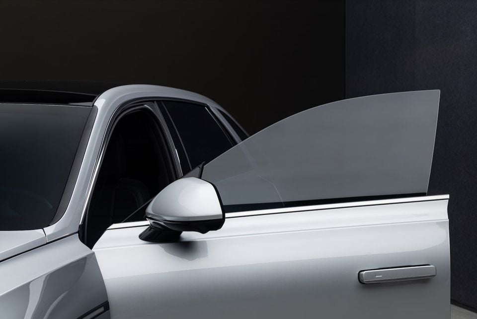 Close-up of a silver car's side profile showing the door, side mirror, window and door handle detail