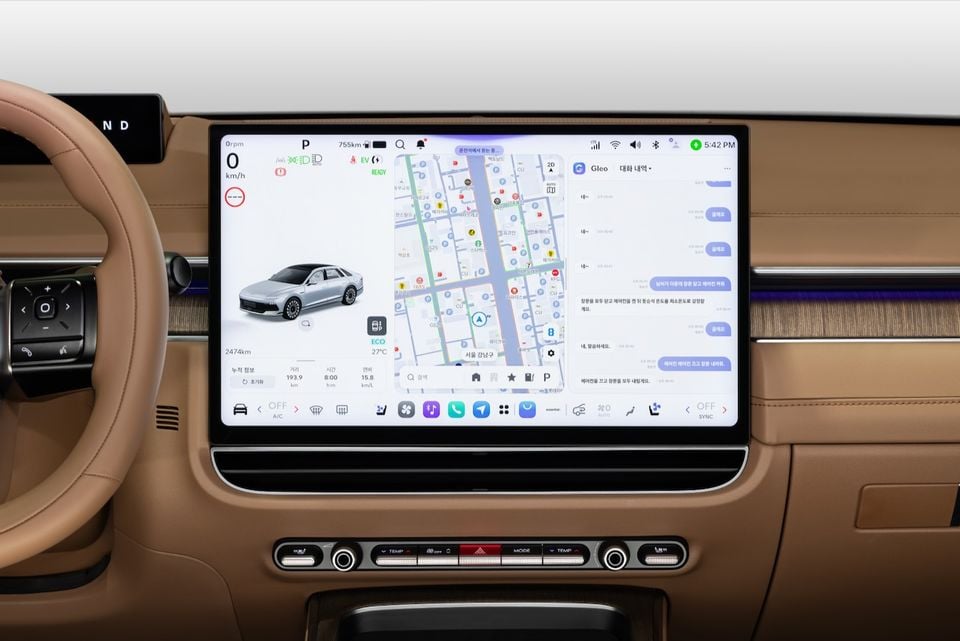 The infotainment touchscreen of a 2027 Hyundai Grandeur, showing a navigation map, vehicle status, and a messaging app with Korean text, set within a tan leather interior dashboard.