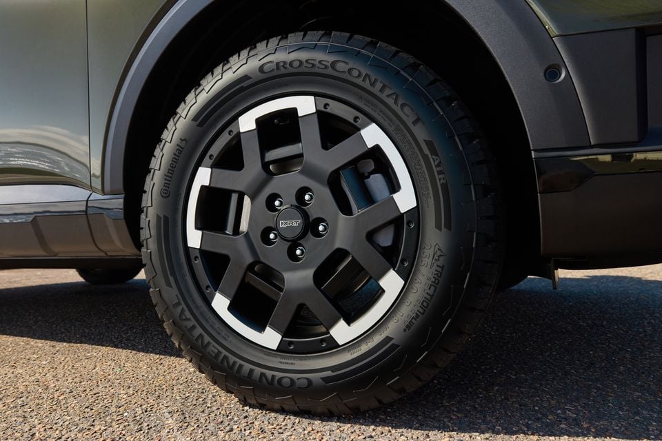 Close-up of a black alloy wheel with Continental CrossContact tyre on a green 2027 Hyundai Palisade XRT Pro