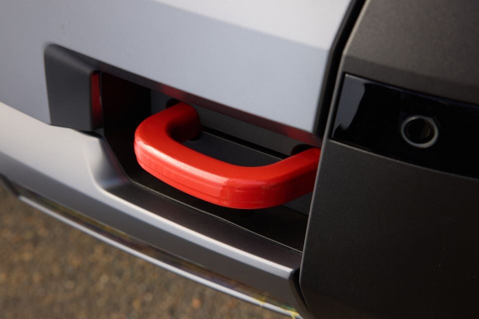 Close-up of a red tow hook mounted in the front bumper recess of a 2027 Hyundai Palisade XRT Pro