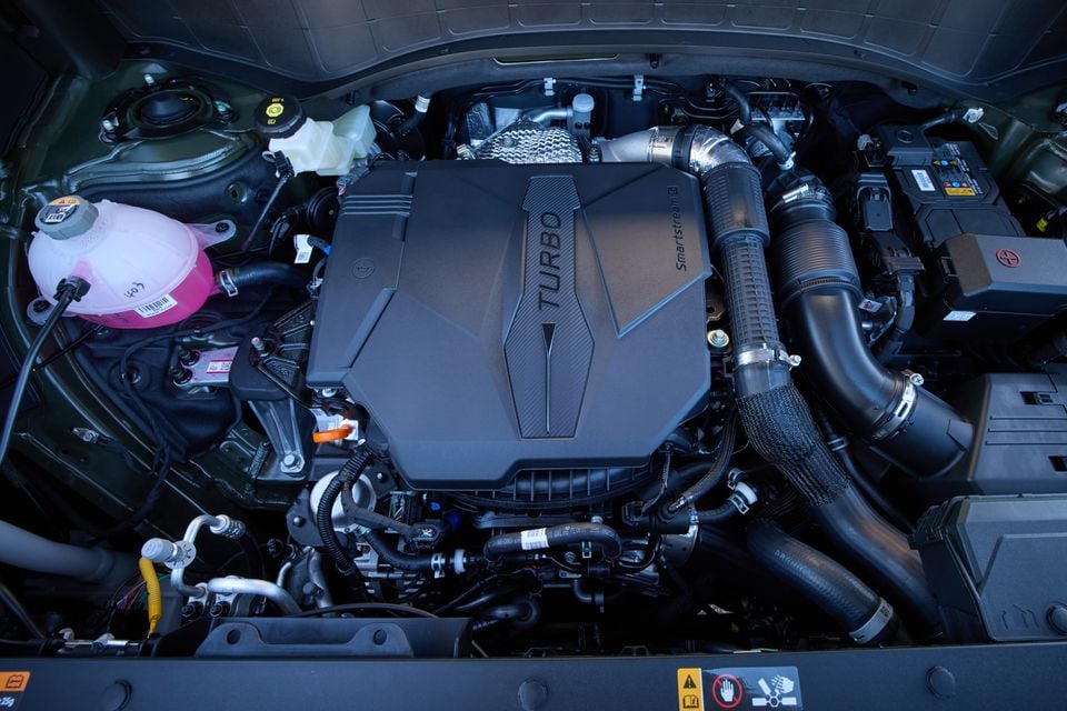 Engine bay of a Hyundai Palisade XRT Pro showing the Smartstream turbocharged petrol engine with intercooler piping and ancillaries