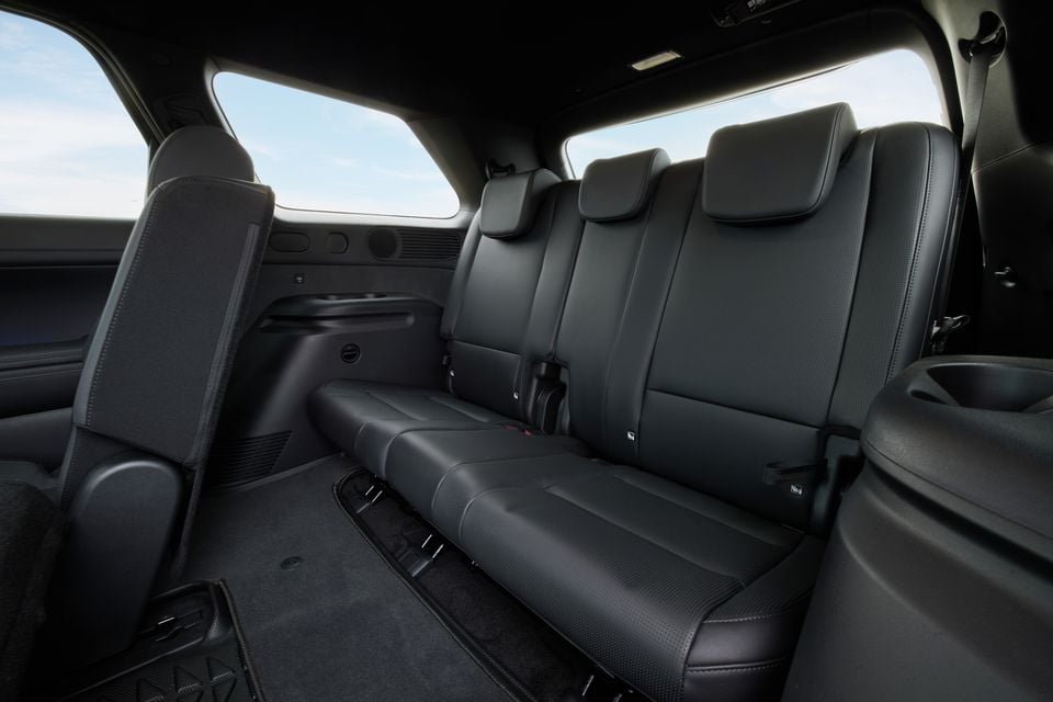 The third-row rear seats of a 2027 Hyundai Palisade XRT Pro, trimmed in black leather with three headrests and a fold-down centre armrest.