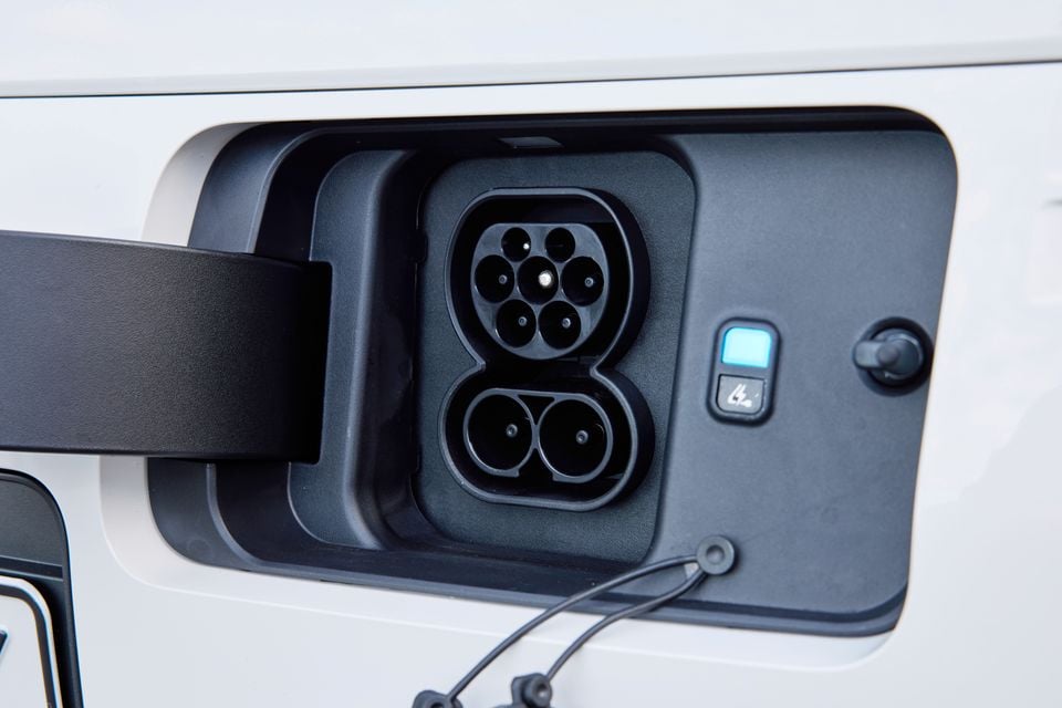 Close-up of a CCS2 (Combined Charging System) charge port on a white Hyundai Staria Load Electric, with the flap open showing the DC fast-charge and AC charging sockets
