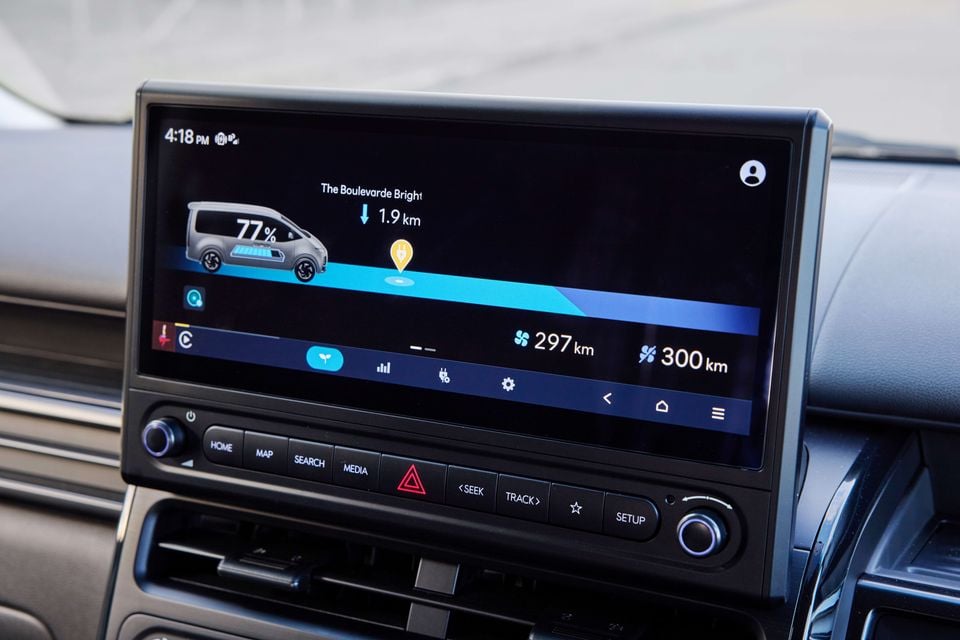 The infotainment screen of a Hyundai Staria Load Electric displaying battery charge at 77%, estimated range of 297–300km, and a nearby charging station 1.9km away