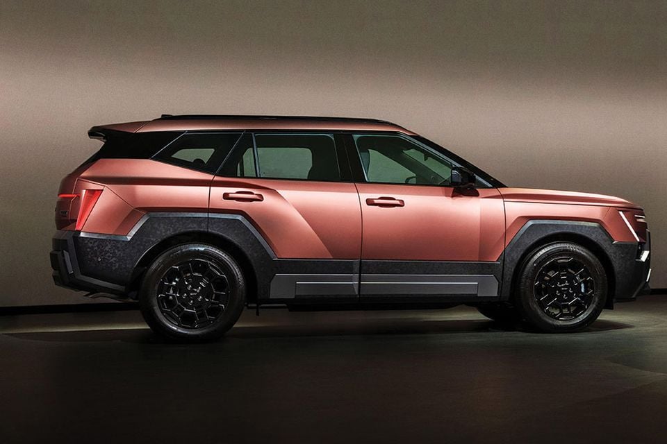 A copper-coloured 2027 Hyundai Tucson XRT SUV shown from the side in a studio