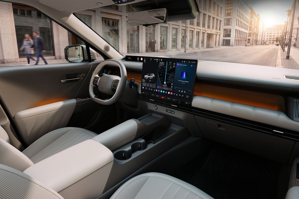 Interior of a 2027 Hyundai Tucson showing the dashboard, large central touchscreen infotainment display, steering wheel, and light beige seats
