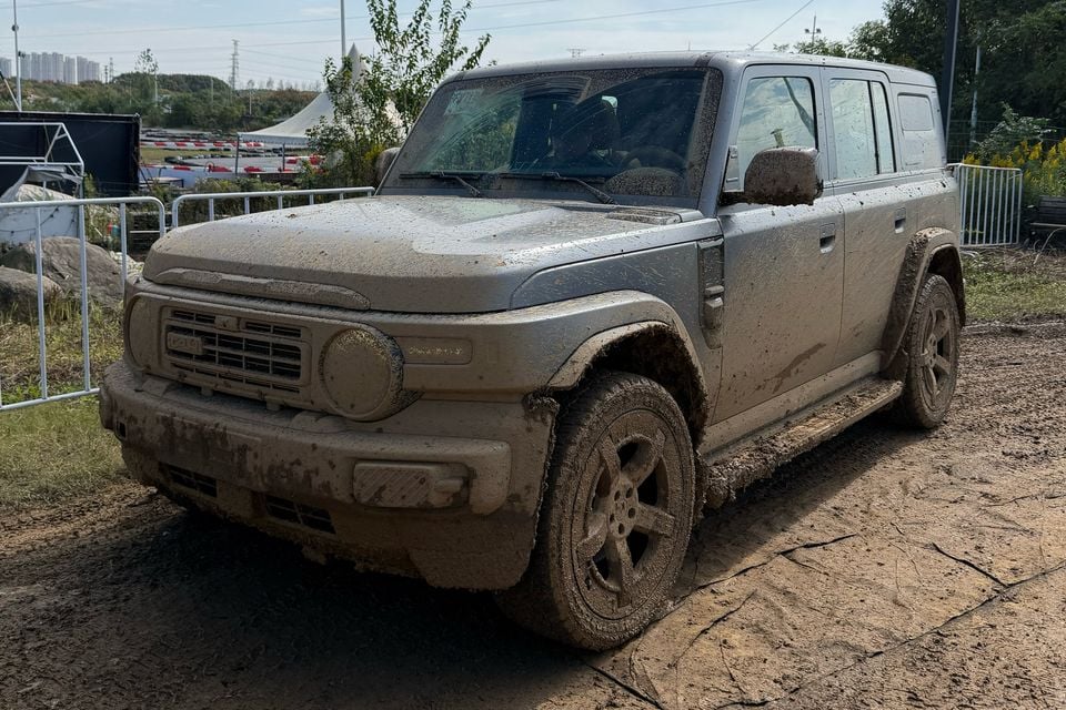 Carro de teste iCaur V25 no exterior: frente enlameada três quartos.