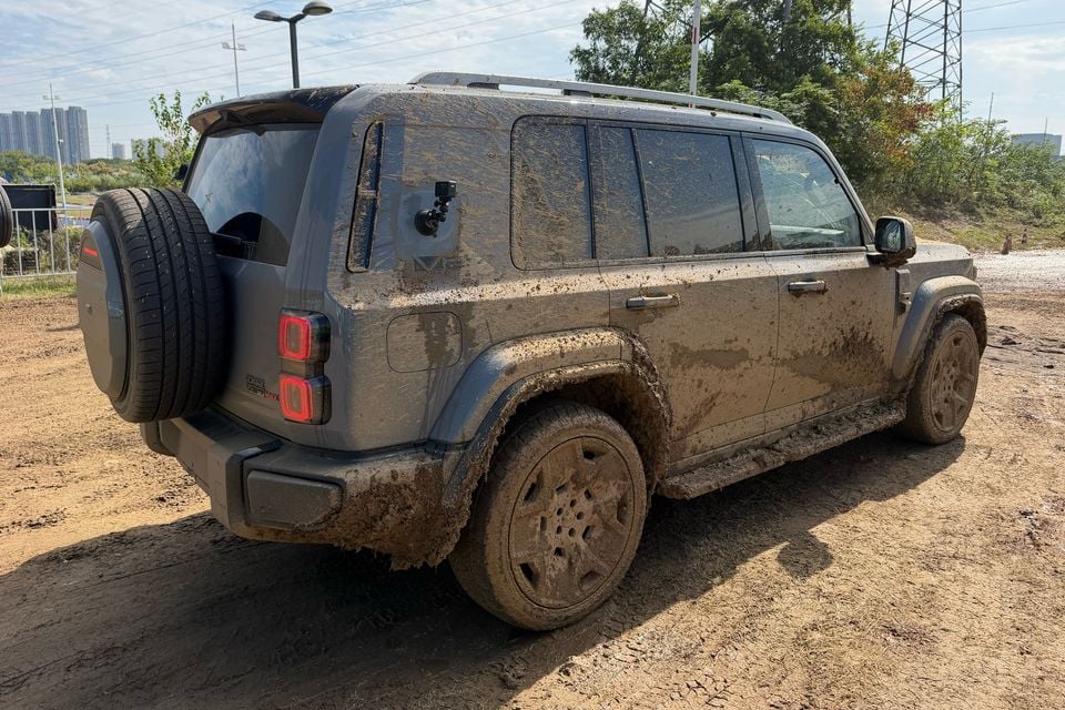 Carro de teste iCaur V27 no exterior: traseira enlameada três quartos.