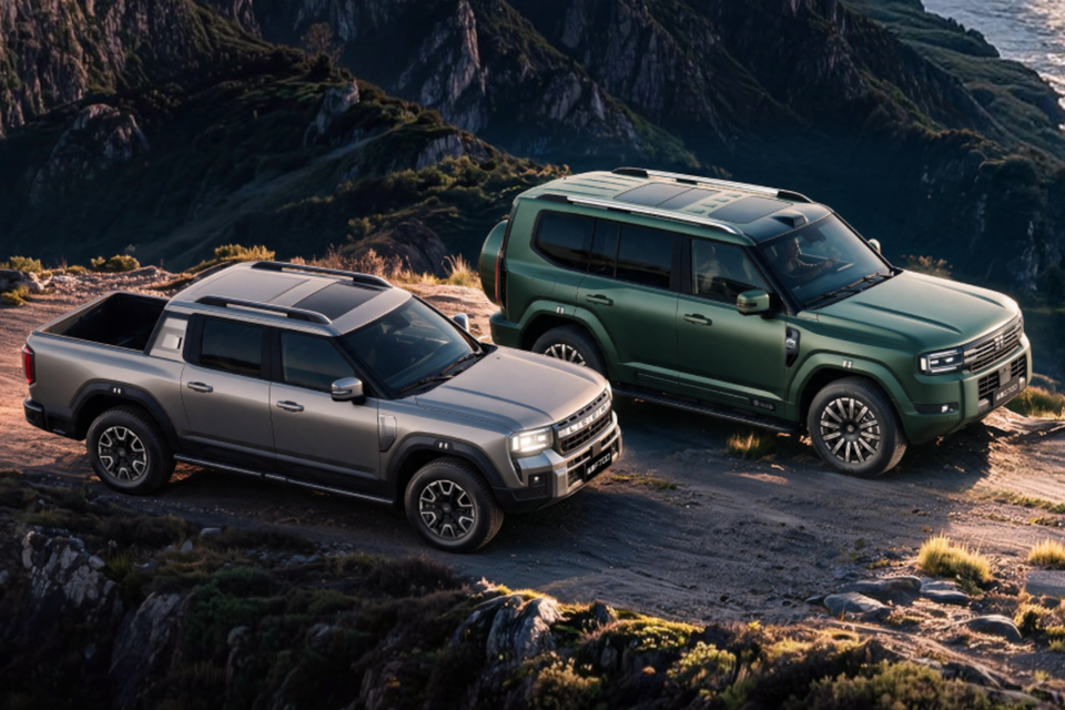 A grey Jetour dual-cab ute and a green Jetour SUV parked side by side on a rugged mountain track above the coast at sunset