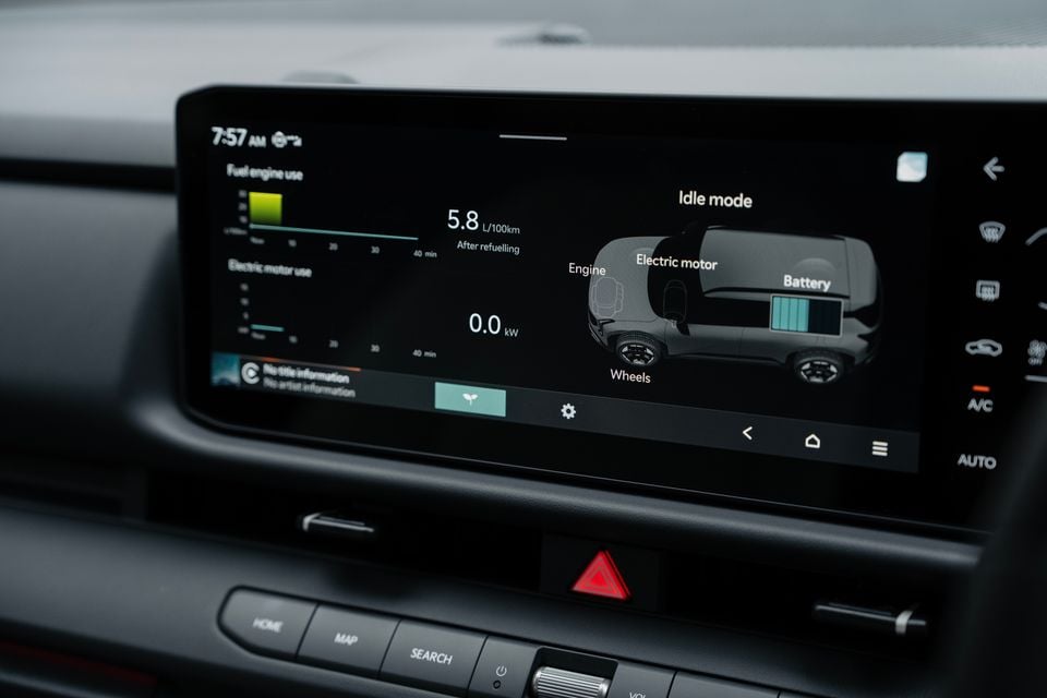 Infotainment touchscreen in the 2027 Kia Seltos GT-Line hybrid showing the hybrid energy flow display in idle mode, with climate buttons alongside