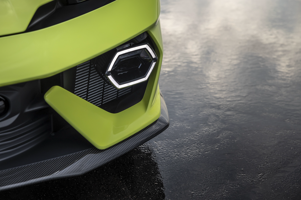 Close-up of the front headlight and carbon-fibre splitter on a lime green Lamborghini Temerario