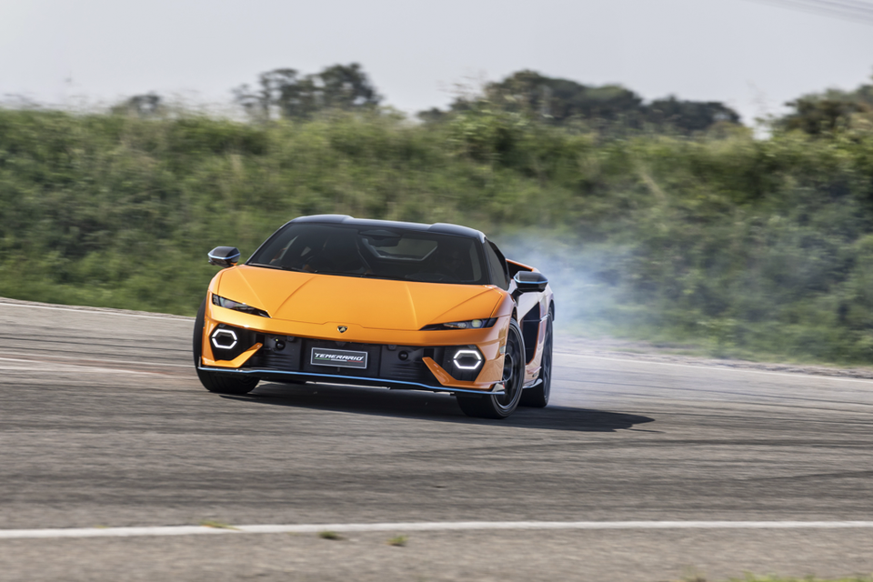 An orange Lamborghini Temerario sports car drifting on a race track with smoke from its rear tyre