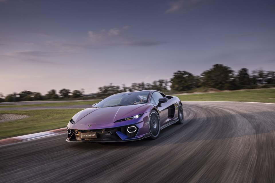 A purple Lamborghini Temerario sports car driving fast around a race track corner