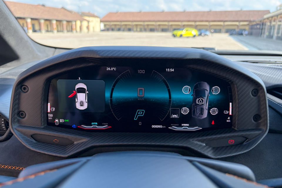 Close-up of the digital instrument cluster in a Lamborghini Temerario, showing a hybrid drive display and carbon fibre surround