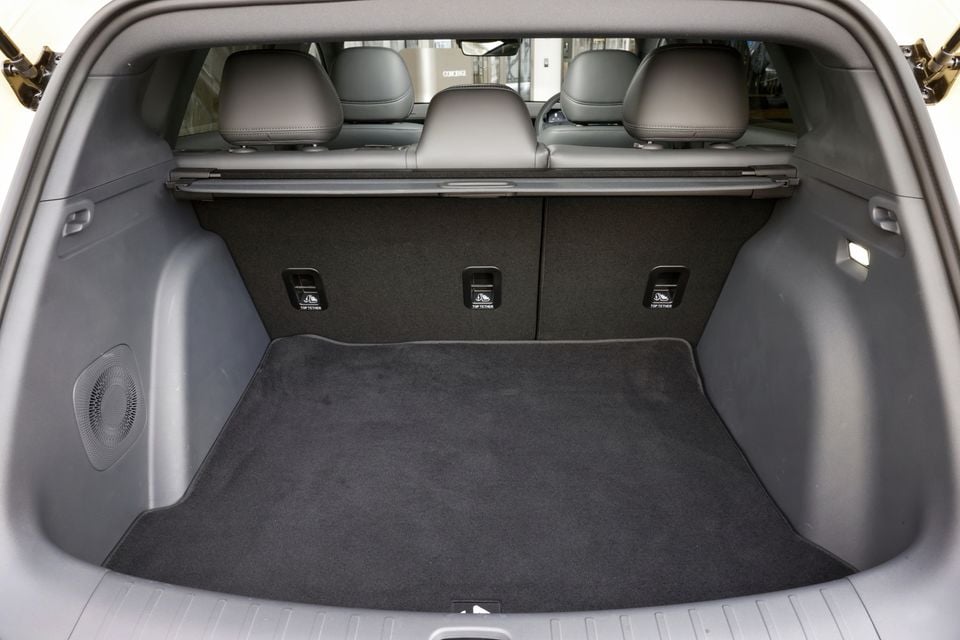 Boot of the 2027 Leapmotor B05 seen through the open tailgate, showing a carpeted cargo floor, cargo cover, side speaker and rear seat top tether points