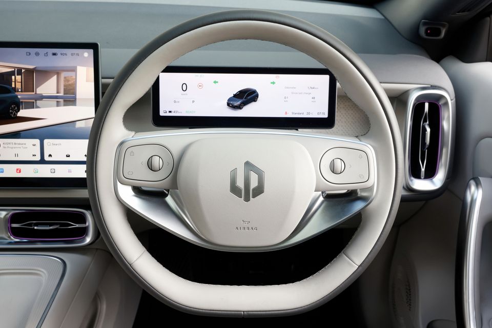 Steering wheel of the 2027 Leapmotor B05 with a light grey leather rim, digital driver display and part of the central touchscreen
