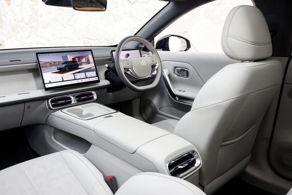 Light grey interior of the 2027 Leapmotor B05 showing the steering wheel, digital driver display, central touchscreen, centre console and front seats