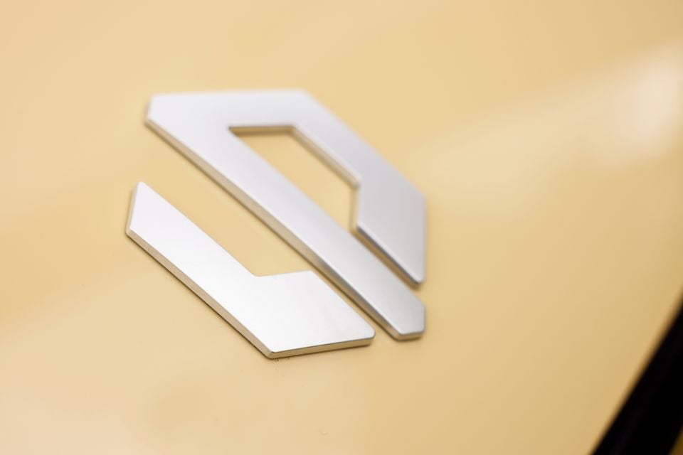 Close-up of the silver Leapmotor badge on the cream bodywork of a 2027 Leapmotor B05
