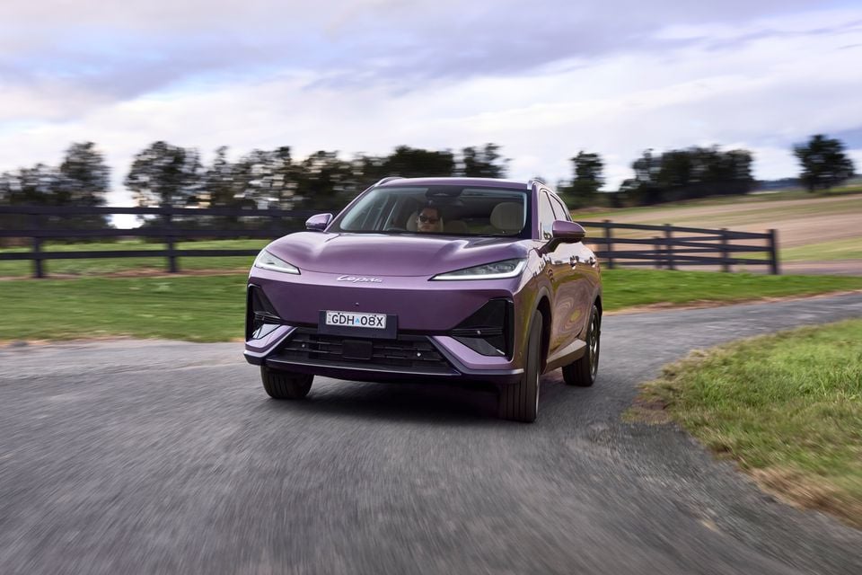 A purple Lepas L6 SUV driving along a rural road, seen from the front