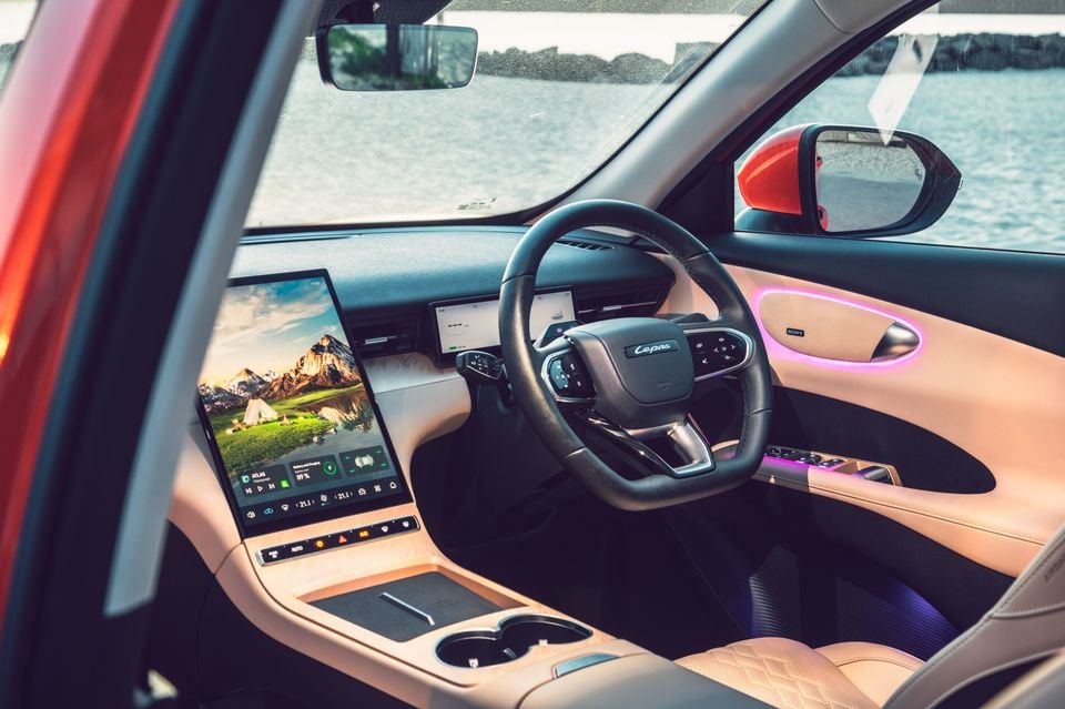 Dashboard of the 2027 Lepas L6 Signature EV seen through the open passenger door, with a portrait touchscreen, steering wheel and tan leather trim