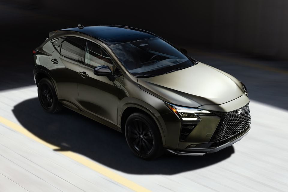 A Lexus NX SUV in olive green with a black roof and black wheels, seen from a high front-side angle on a paved surface