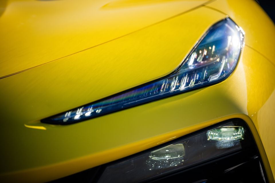 Close-up of the slim LED headlight on a yellow 2027 Lotus Eletre X, with the lower front lighting cluster below