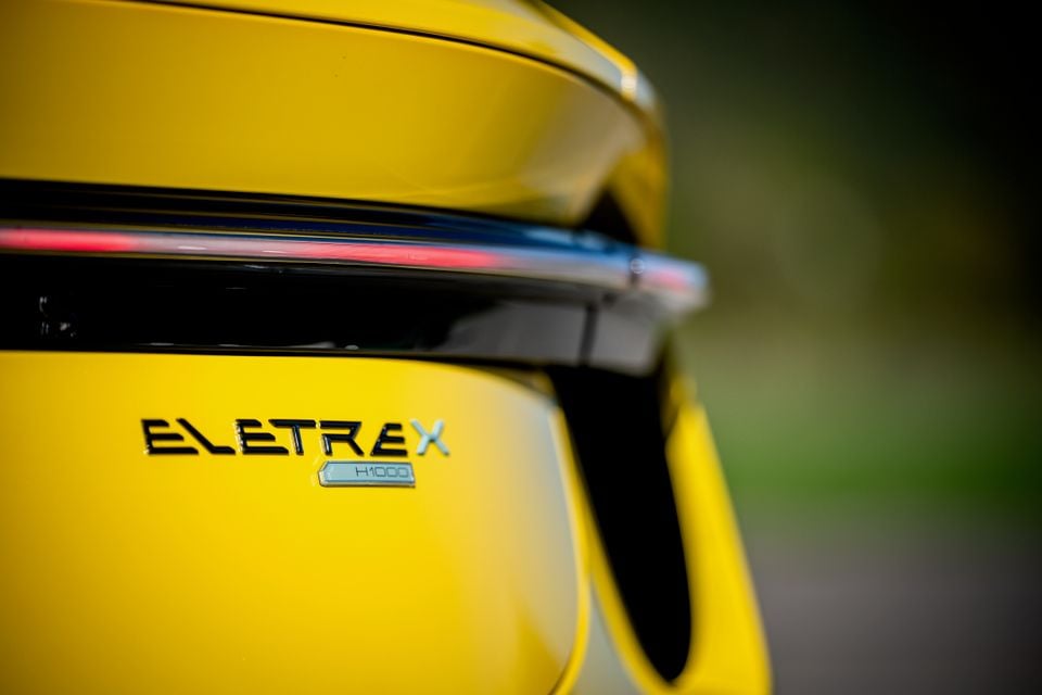Close-up of the Eletre X H1000 badge on the yellow tailgate of a 2027 Lotus Eletre X, below its full-width light bar