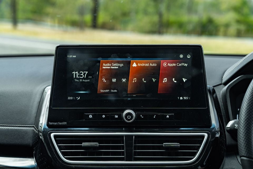 The infotainment touchscreen inside a Mahindra XUV 3XO showing Harman Kardon audio settings, Android Auto and Apple CarPlay options on the home screen.