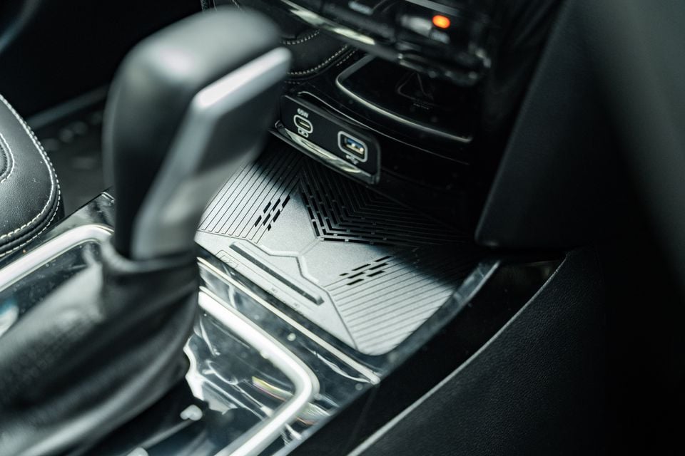 Close-up of the centre console in a Mahindra XUV 3XO Black Edition, showing USB-C and USB-A charging ports alongside a wireless charging pad and gear selector