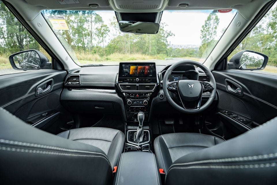 Interior view of a Mahindra XUV 3XO showing the dashboard, touchscreen infotainment system, steering wheel, centre console and front seats