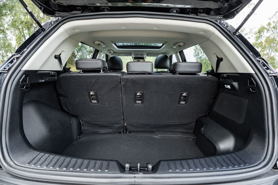 The open boot of an SUV showing the cargo area with rear seats visible, ISOFIX top-tether anchors on the seatbacks, and a panoramic sunroof visible through the cabin